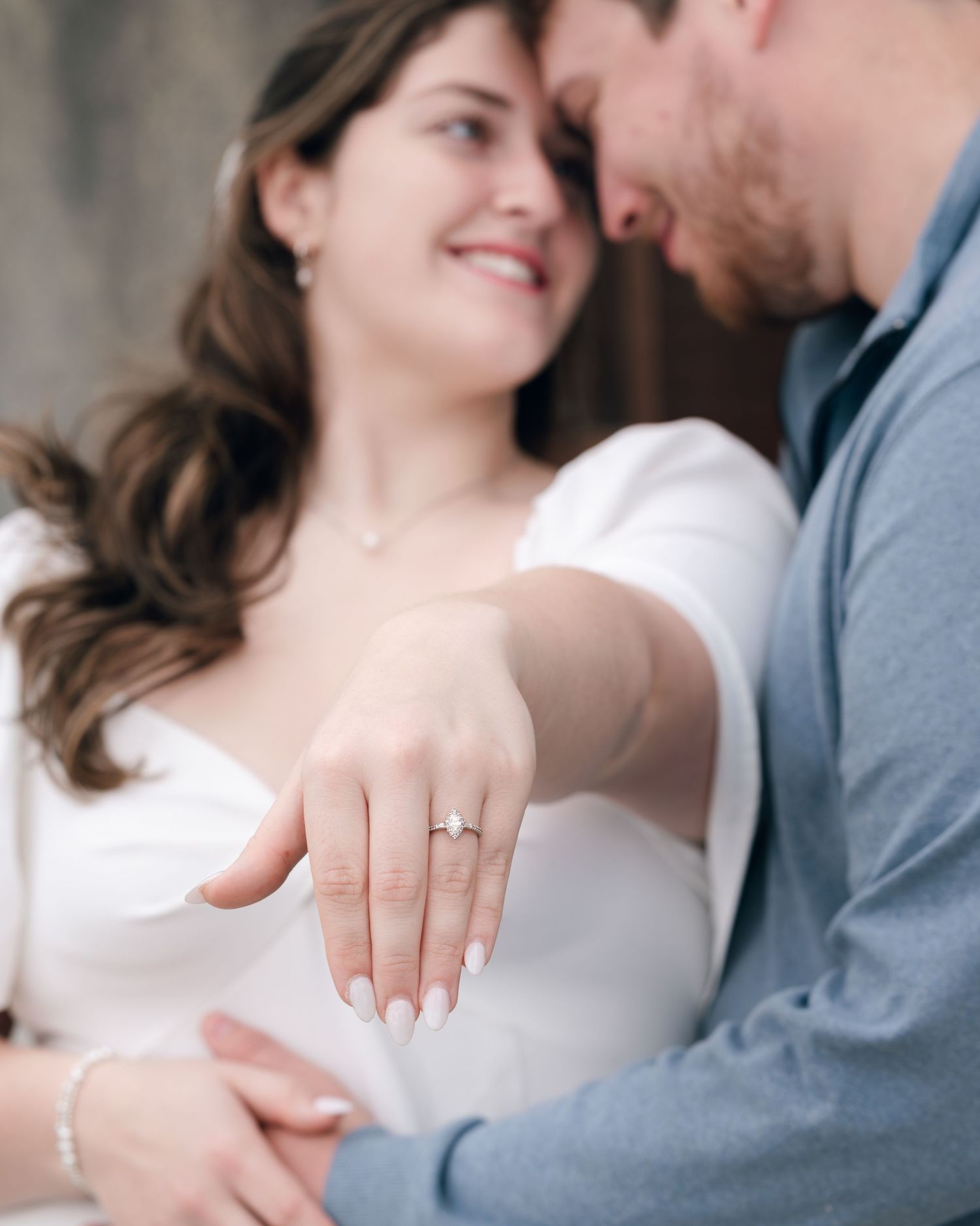 A romantic moment showing off a new engagement ring in soft natural lighting.