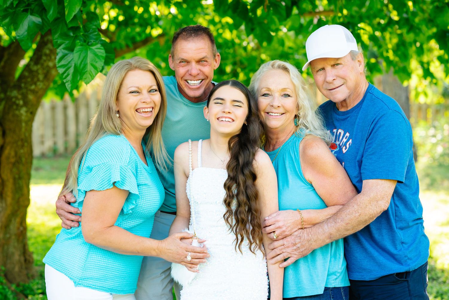 Happy family group photos outdoors with coordinated turquoise and blue casual wear.