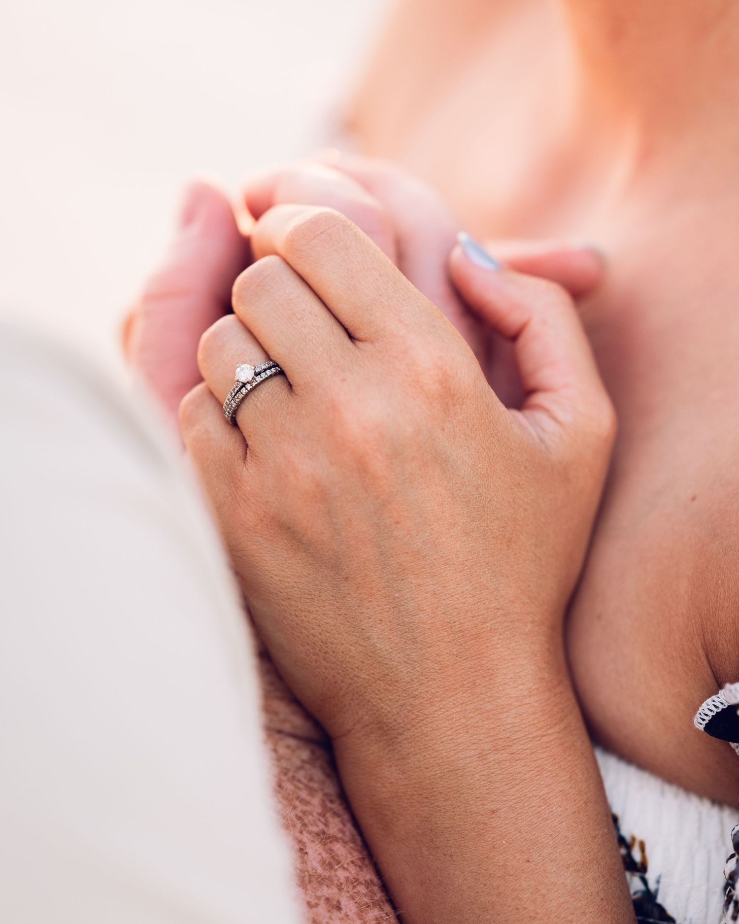 Close-up details of hands and rings during an intimate moment.