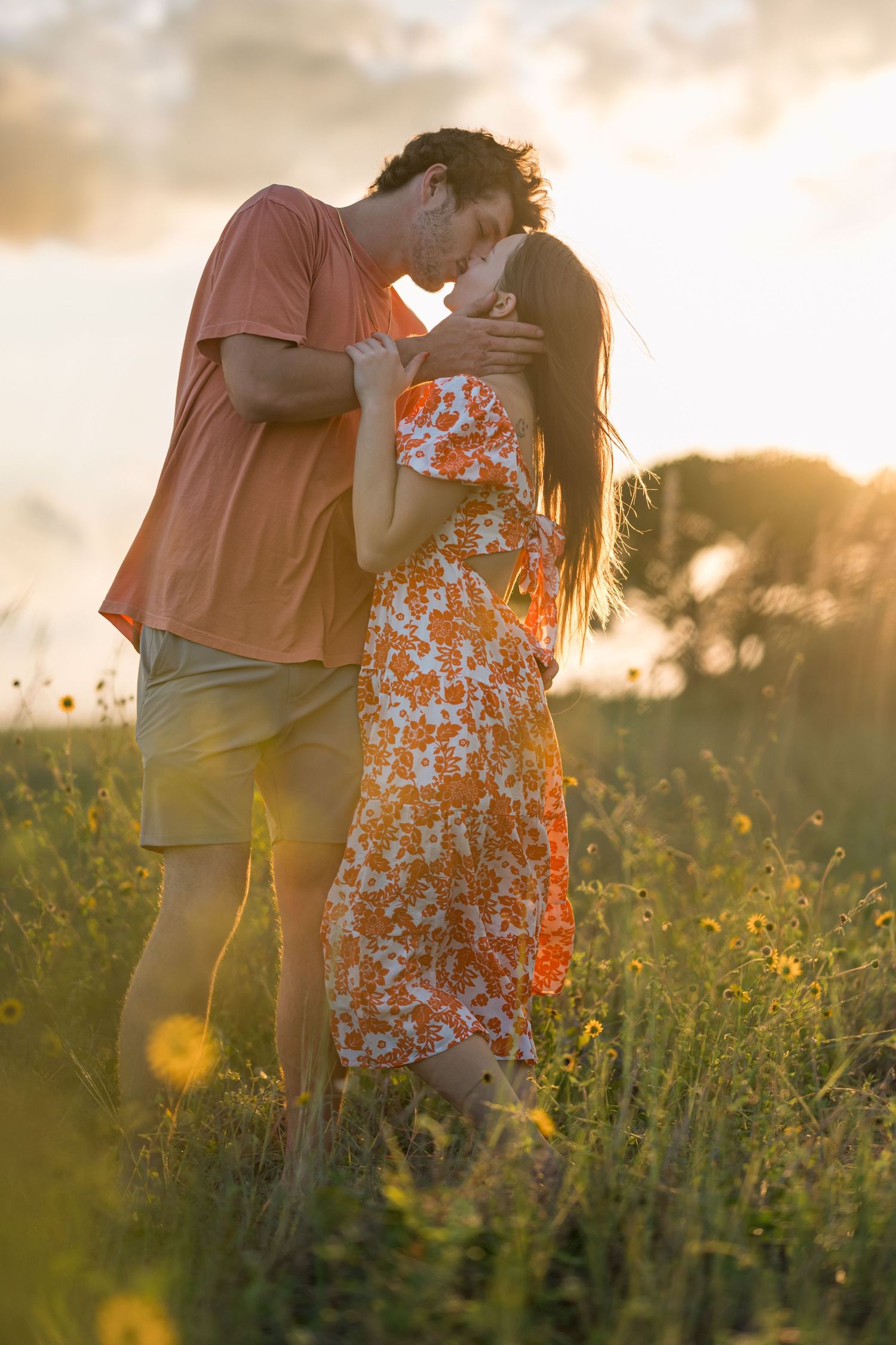 A romantic sunset photoshoot in a wildflower field with soft golden lighting.