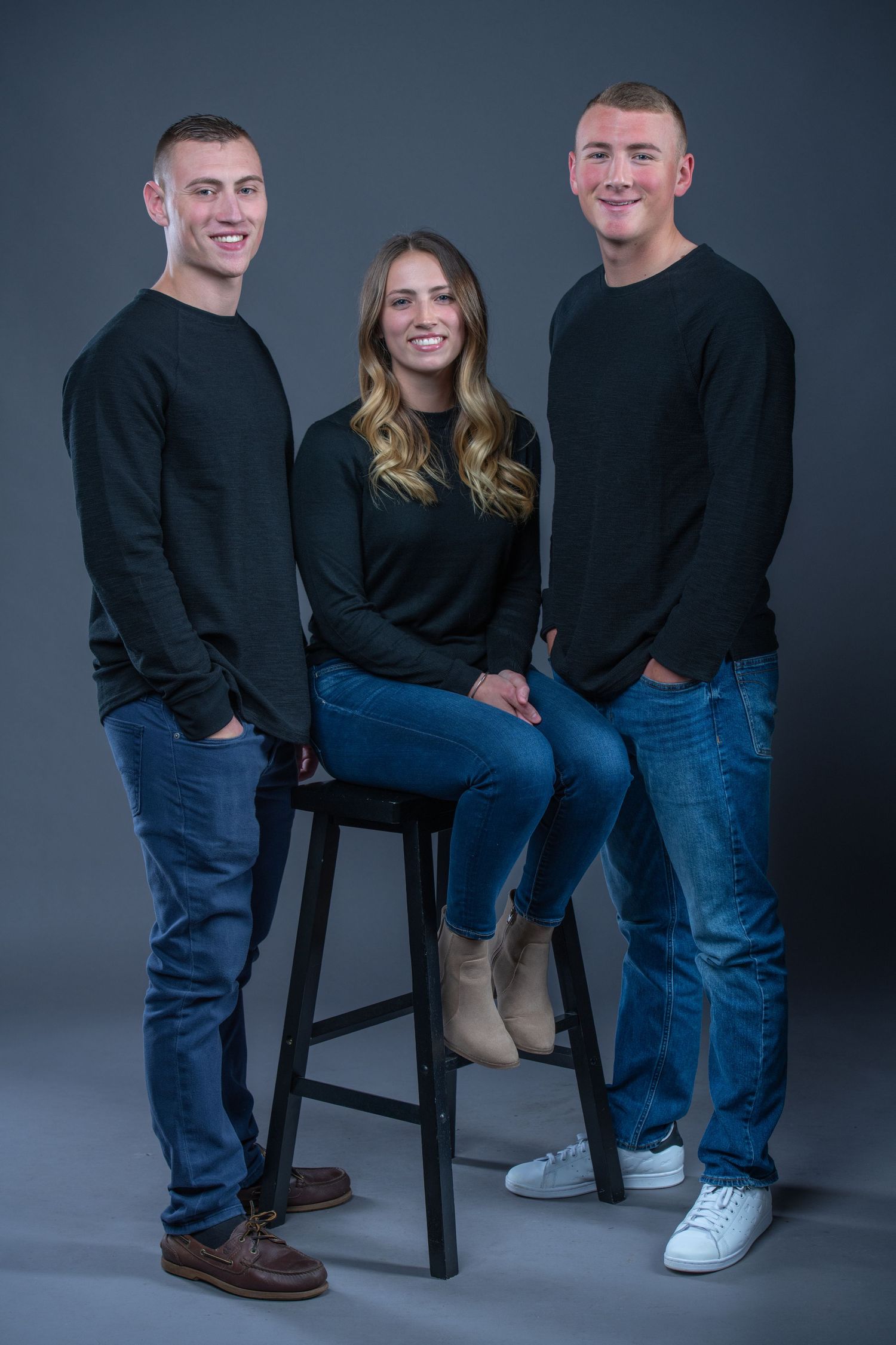 Studio portrait series showing family members in matching black sweaters and jeans.