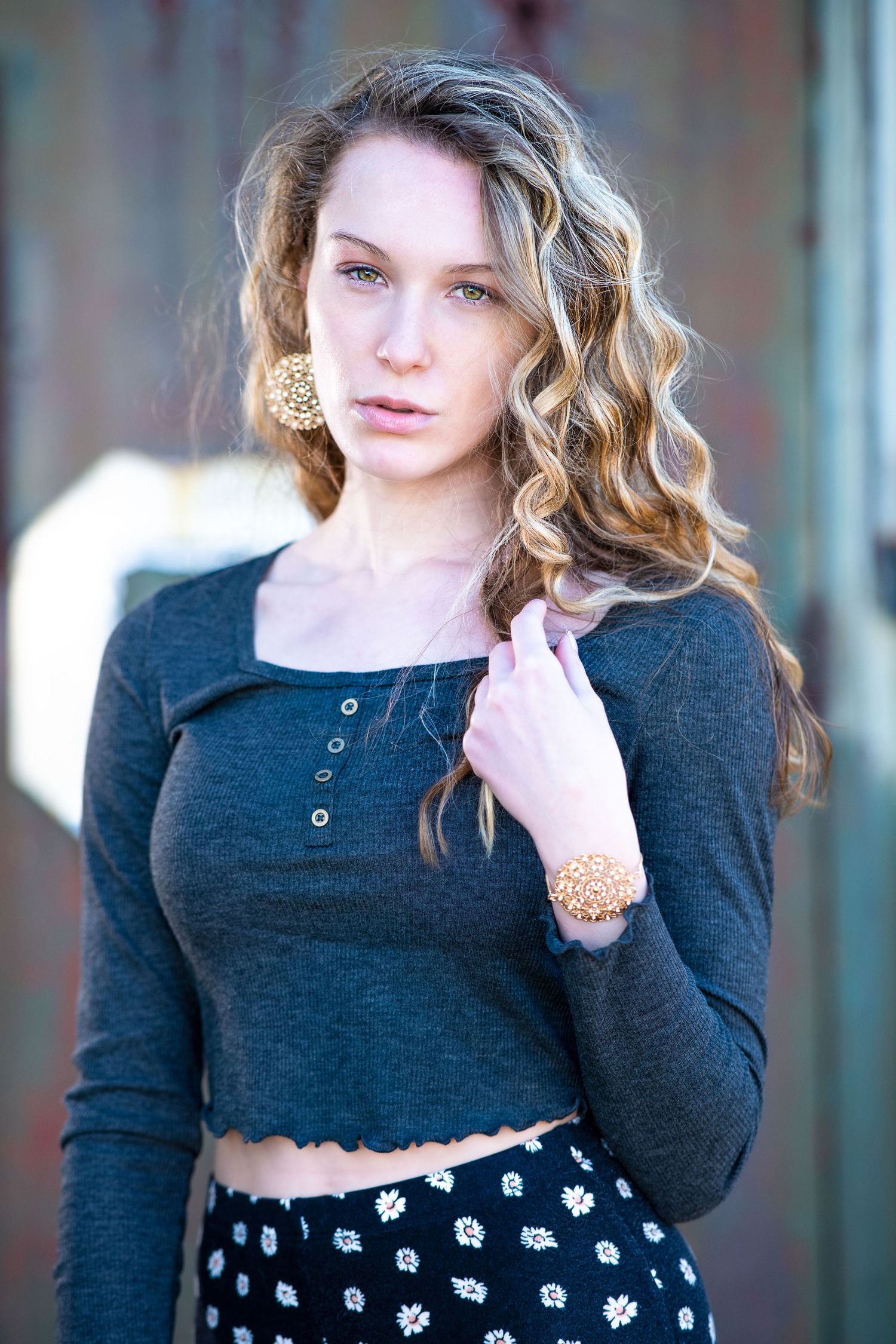 A cropped black sweater paired with a floral skirt creates a casual outdoor look.