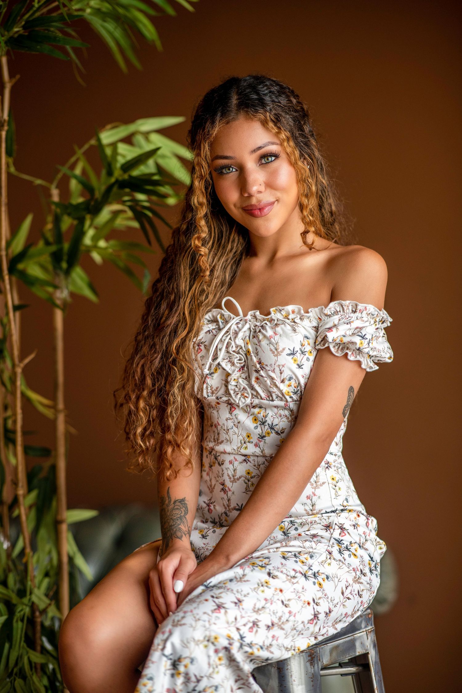 A series of artistic portraits showing someone in a delicate white floral dress against a warm brown background with plants.