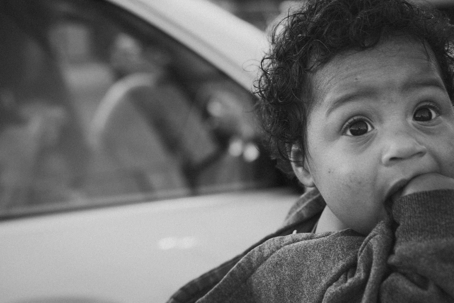 Black and white close-up portrait showing partial faces in natural lighting.