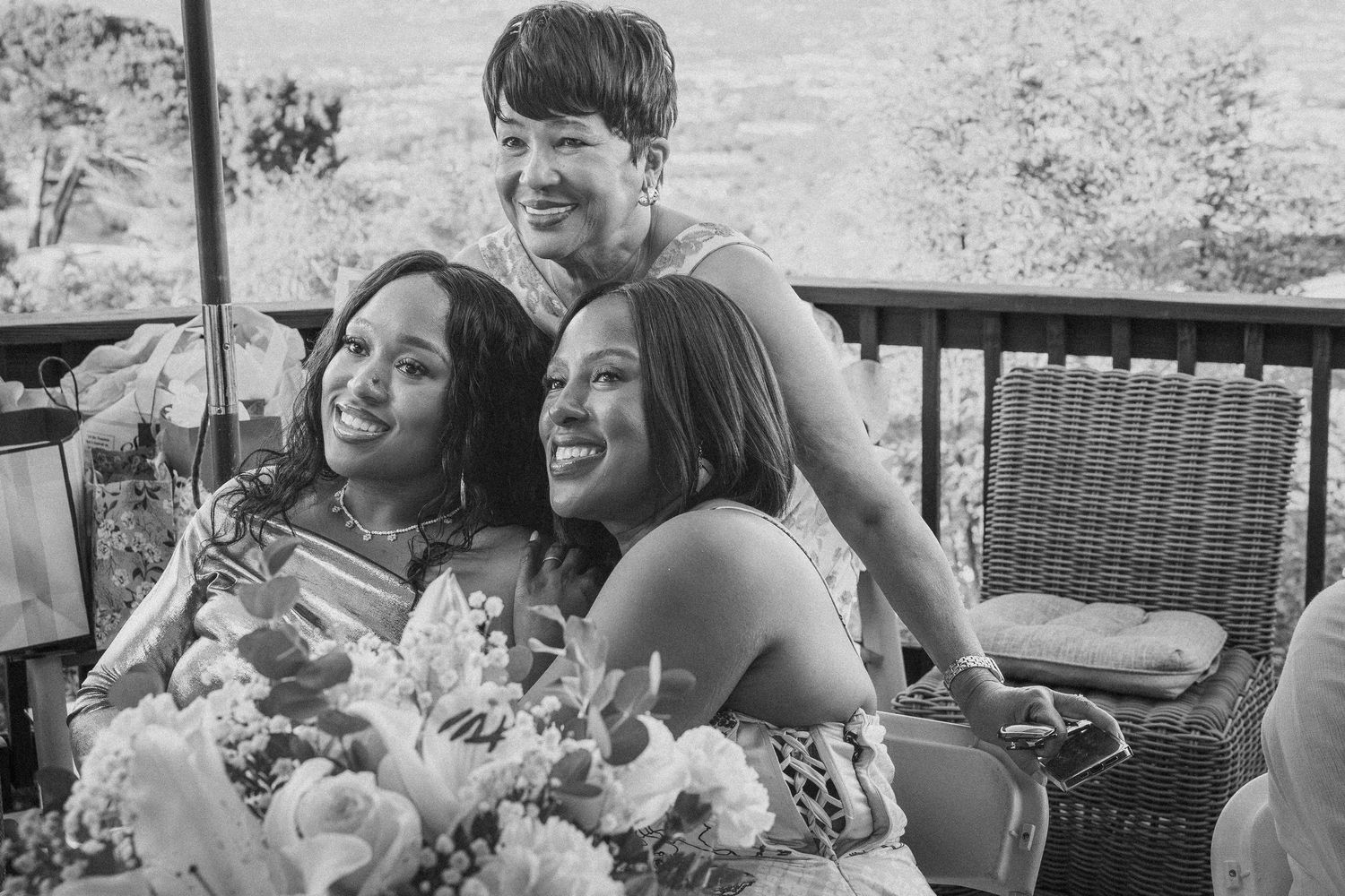 Group enjoying outdoor celebration with flowers and laughter.