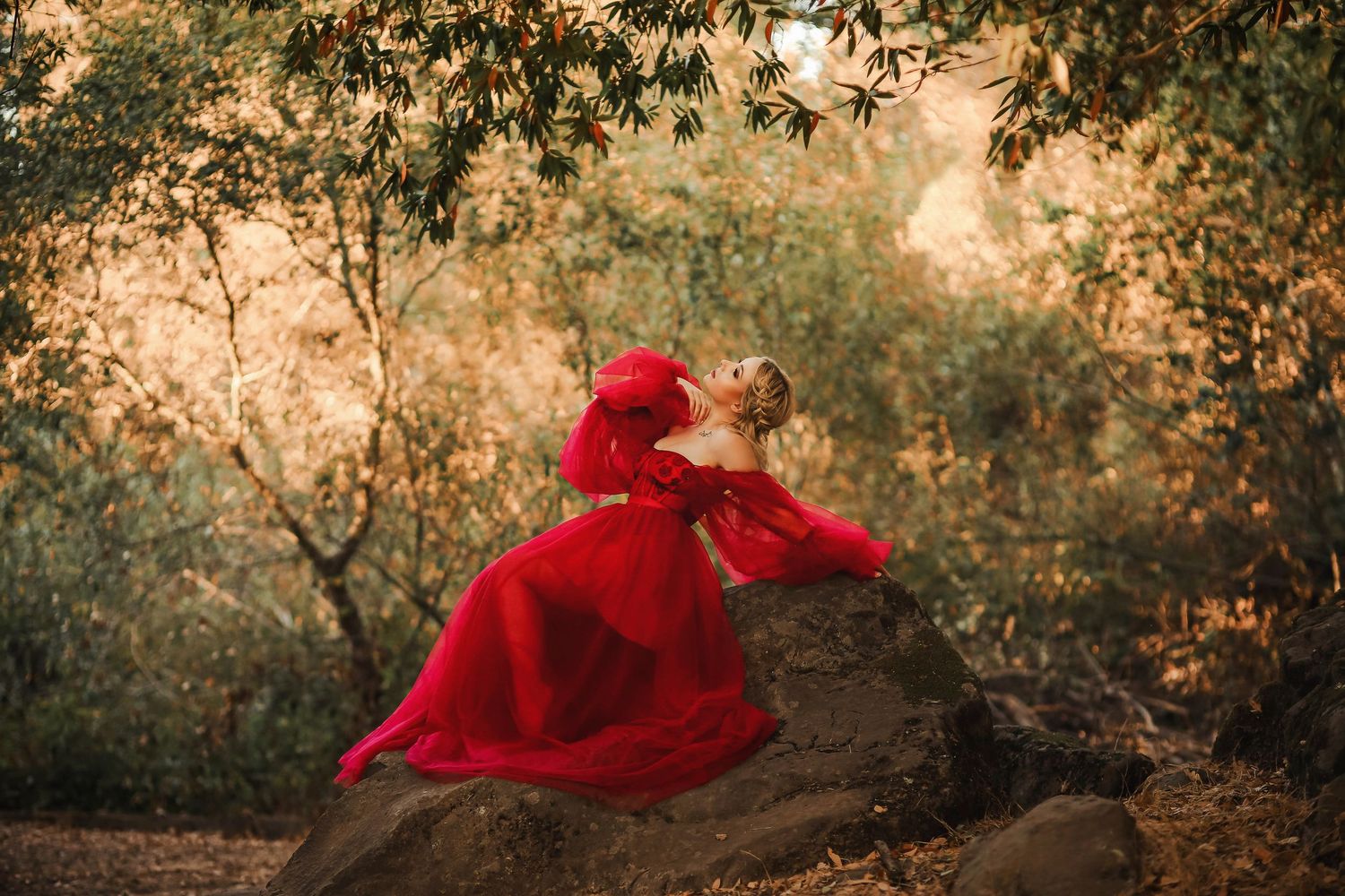 A figure in a flowing red dress in motion against a dreamy autumn forest background.