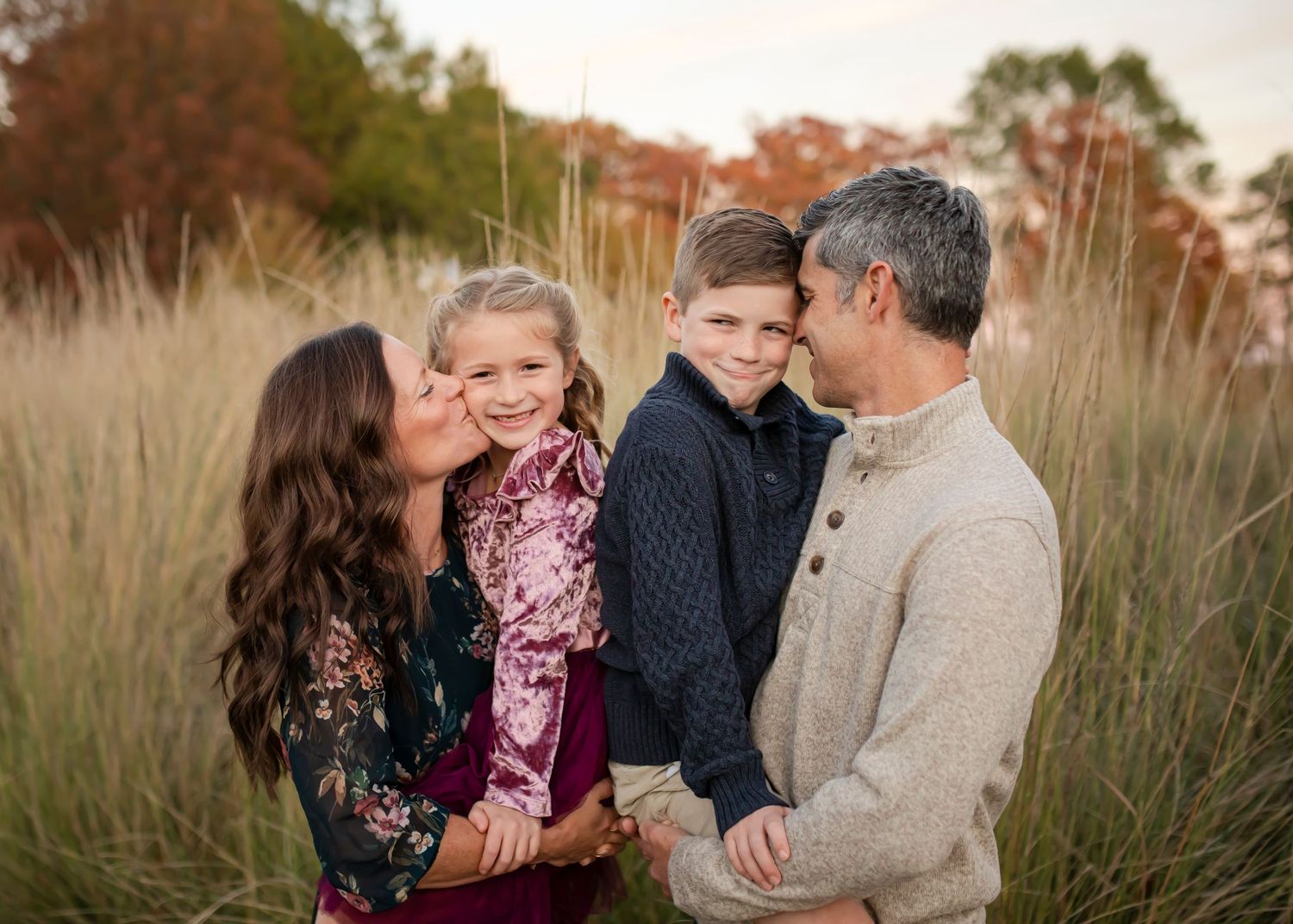 Family in a golden field at sunset during autumn photo session.