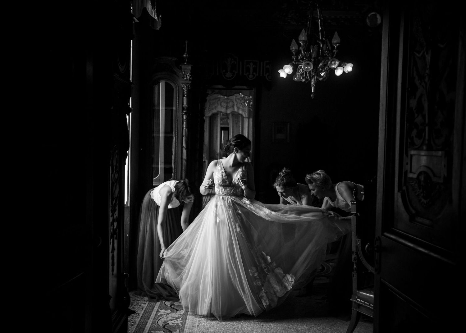 A bride gets dressed in the cathedral in Malta with the help of her sisters.