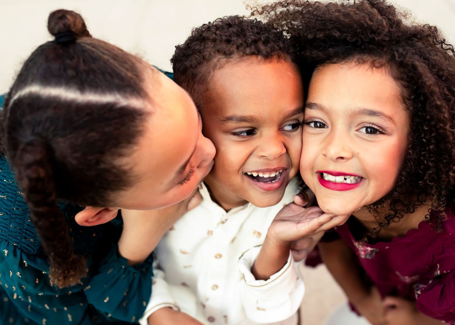 Children sharing secrets and whispering to each other while smiling.