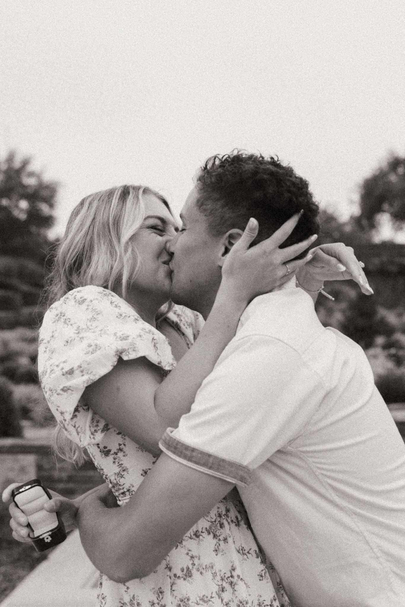 A romantic black and white photo sequence shows a couple sharing passionate kisses outdoors.