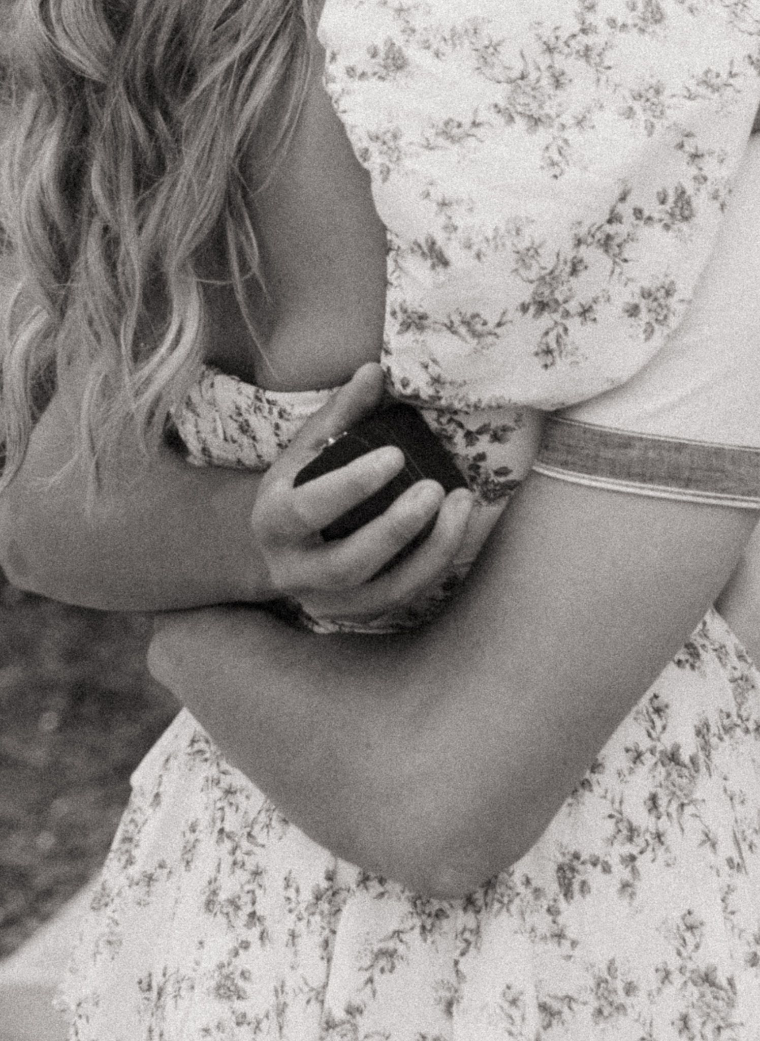 Black and white artistic photo series showing hands holding a delicate teacup against floral wallpaper.