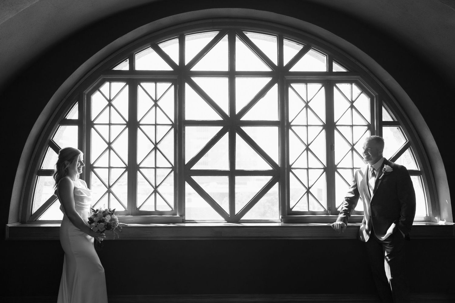 A black and white architectural series showing arched windows with geometric patterns and silhouetted figures.