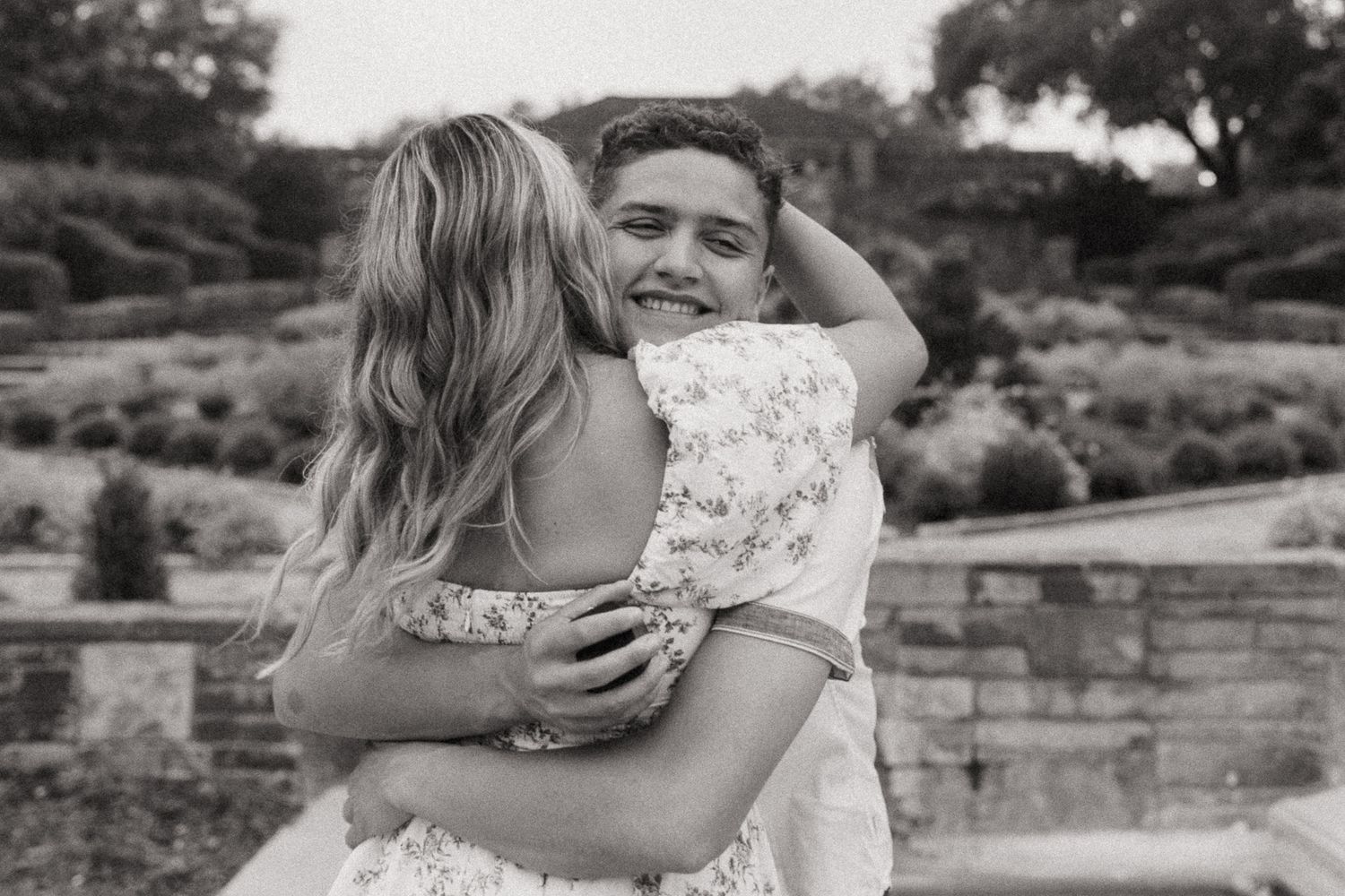 Black and white collage of intimate wedding moments showing embraces and kisses in an outdoor garden setting.