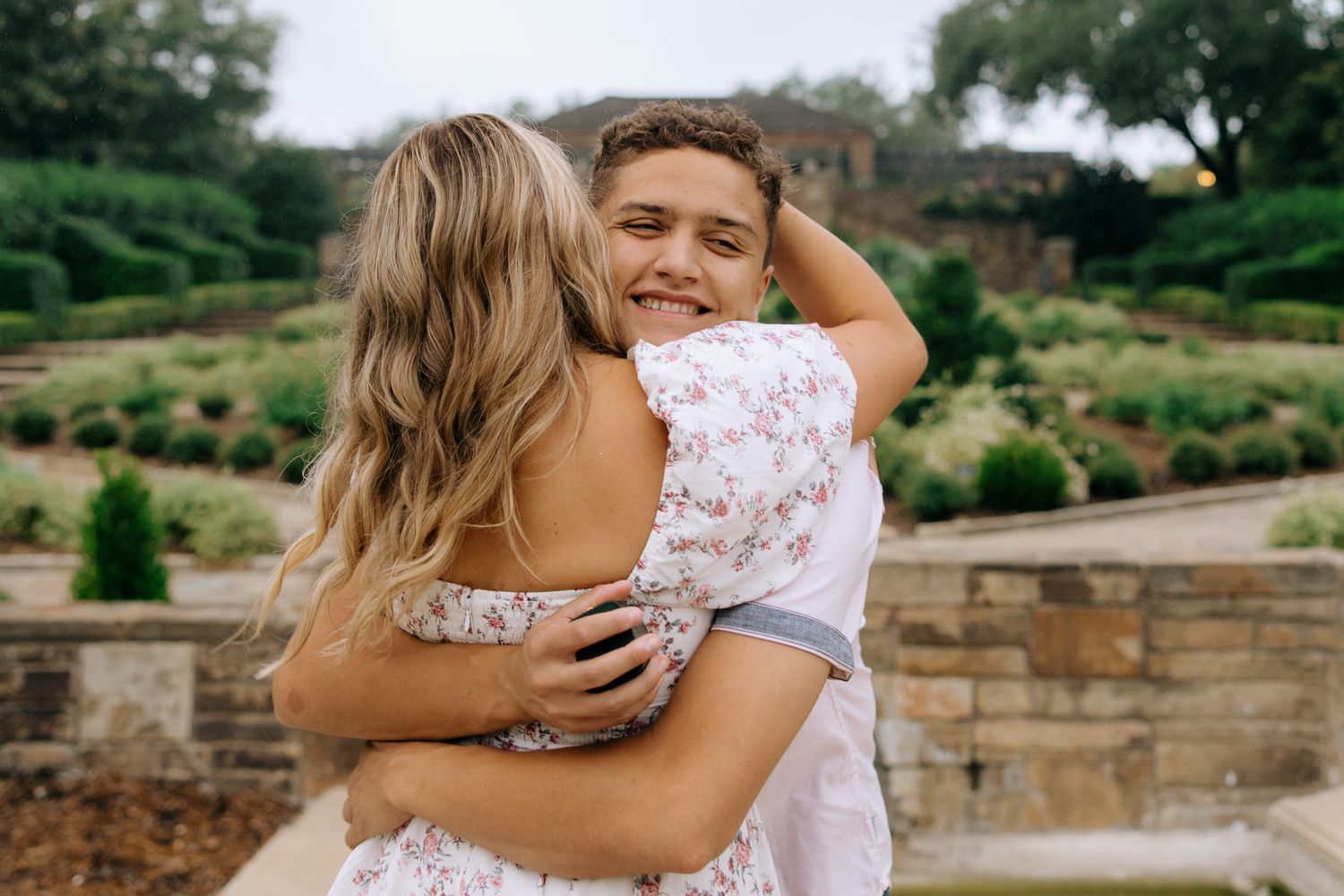 A series of romantic outdoor wedding photos showing tender embraces between a couple in a garden setting.