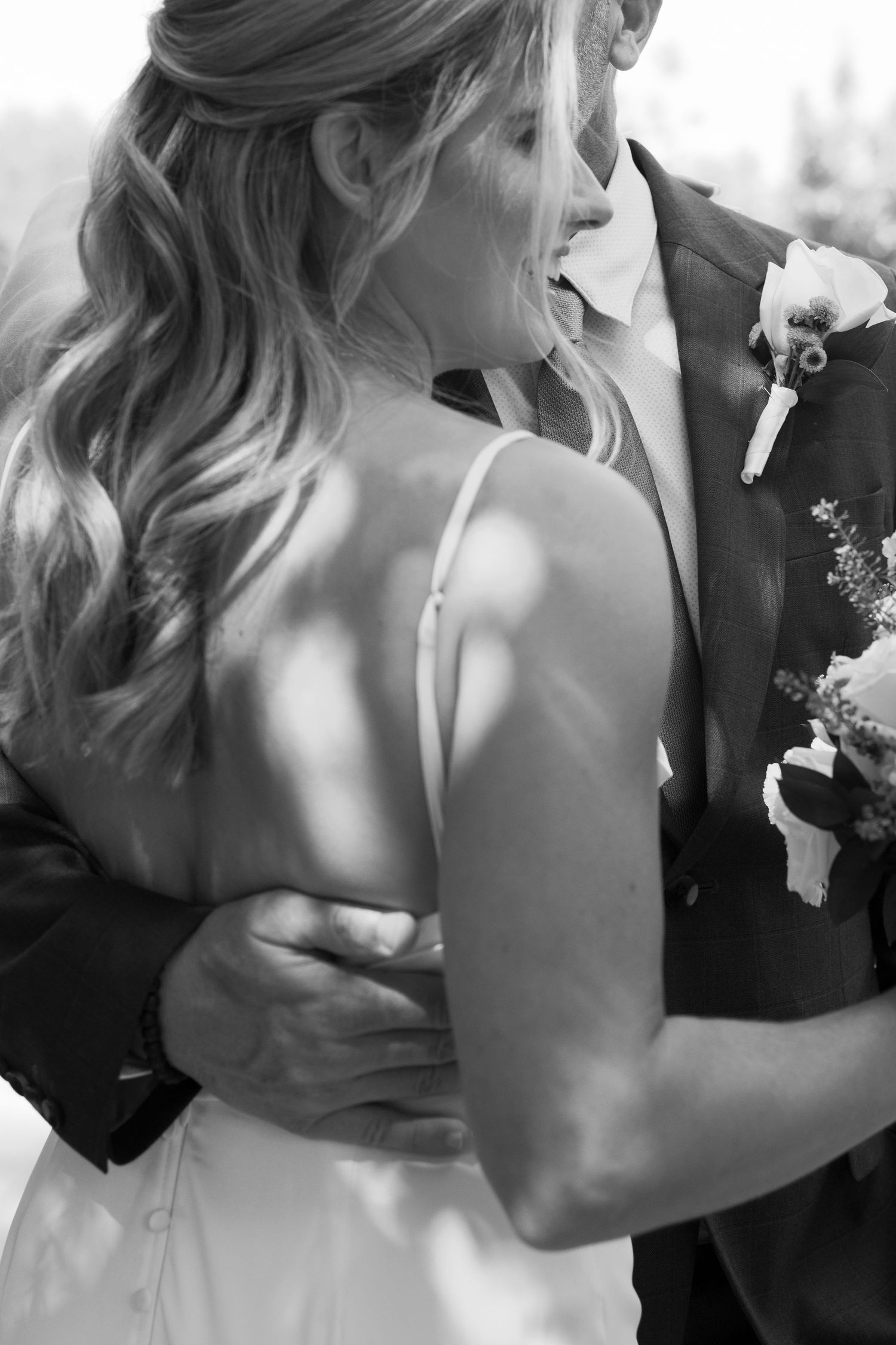 Black and white wedding photo sequence showing a romantic kiss between a couple in formal attire.