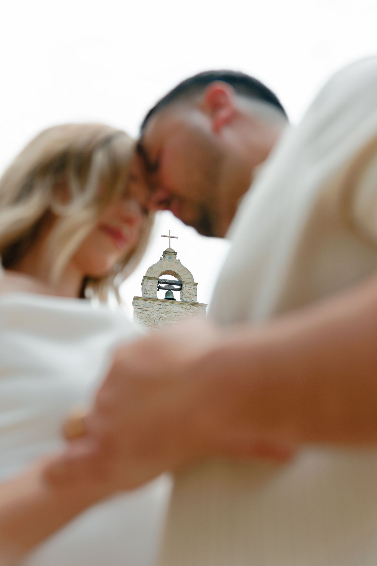 A close-up view of a small bell tower or steeple against a soft blurred background.