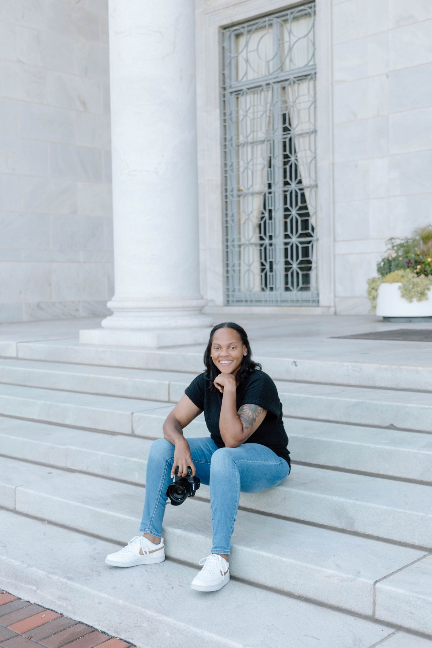 Casual portrait session on white stone steps with architectural columns.