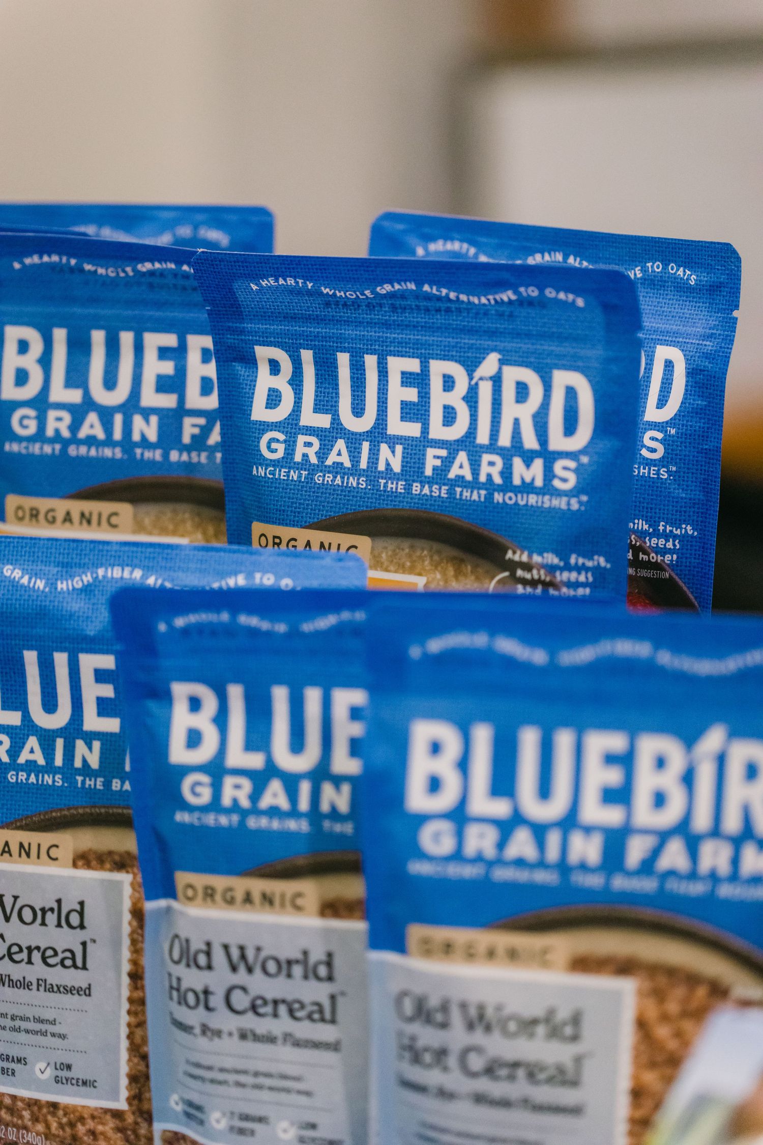 Multiple bags of Bluebird Grain Farms organic Old World Hot Cereal displayed on a store shelf.