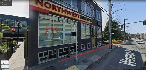 Exterior street view of Northwest restaurant with large signage, black facade, and red accents on a city corner.