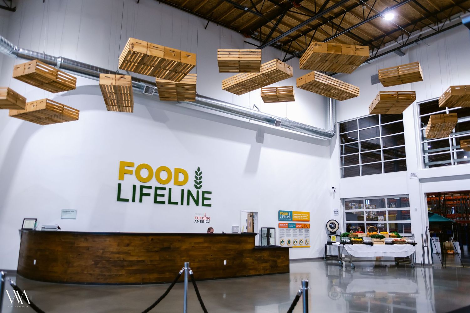 Food Lifeline organization lobby with wooden pallet ceiling art installation and curved reception desk.