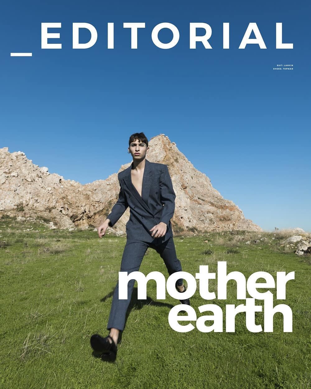 Editorial magazine cover featuring male model in grey suit on rocky green landscape with mother earth typography.