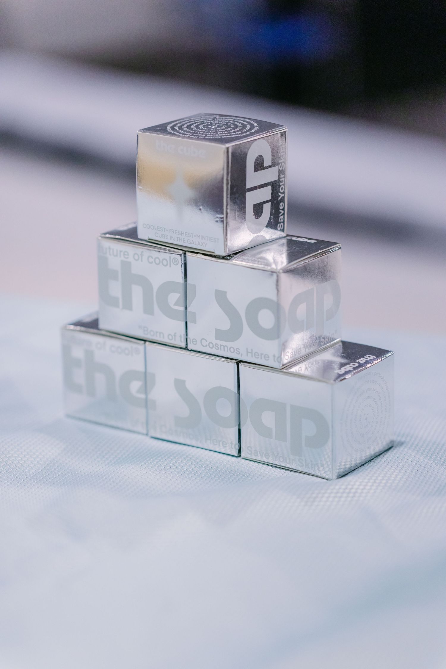 Silver metallic cubes stacked in a pyramid shape with The Soap branding on a white surface.
