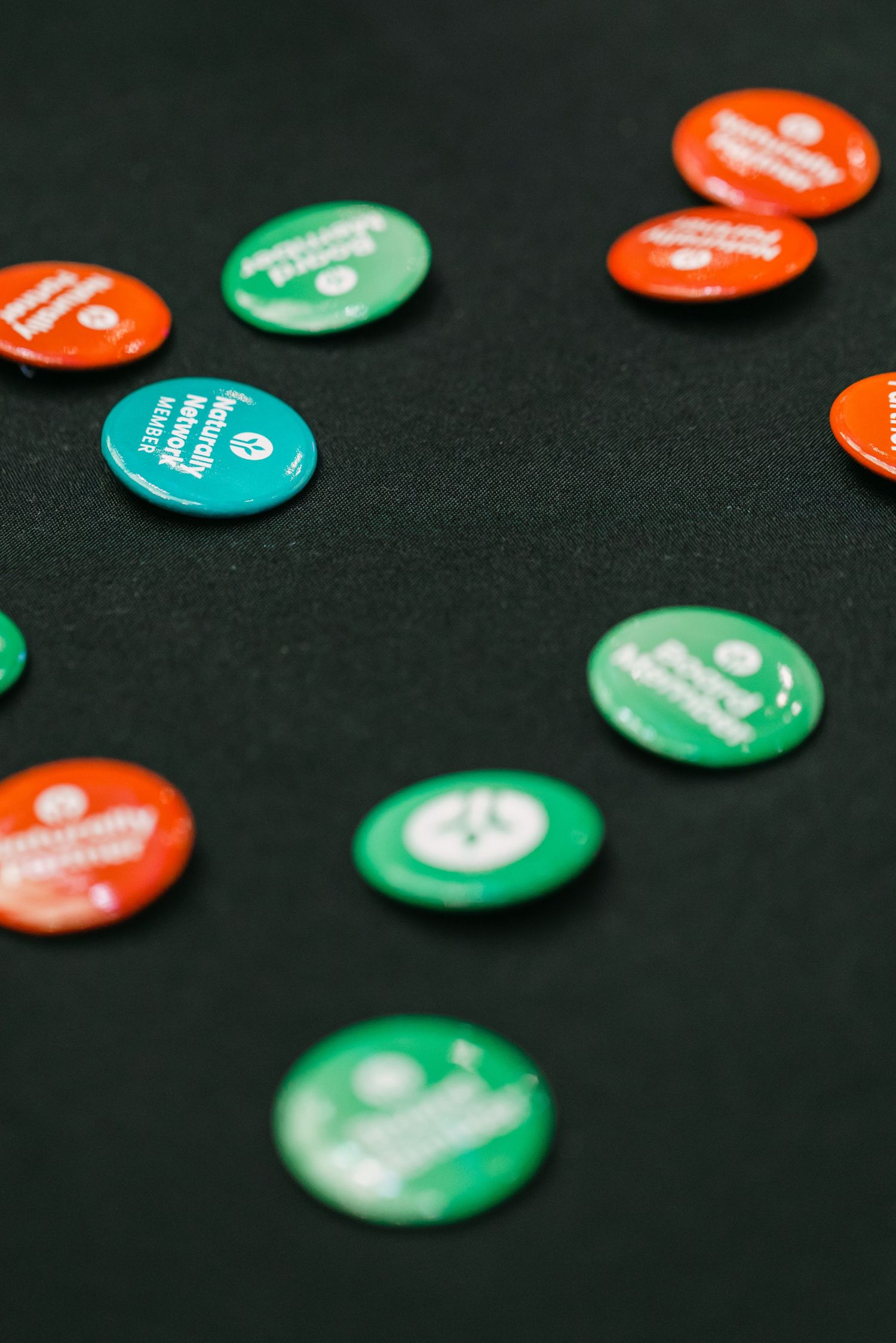 Colorful green and orange promotional buttons scattered on a dark background.