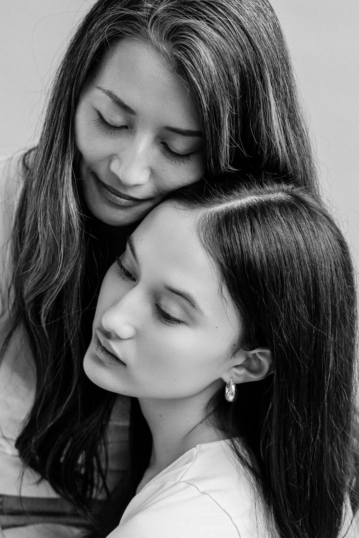 Mother and daughter share a tender, peaceful moment in black and white.