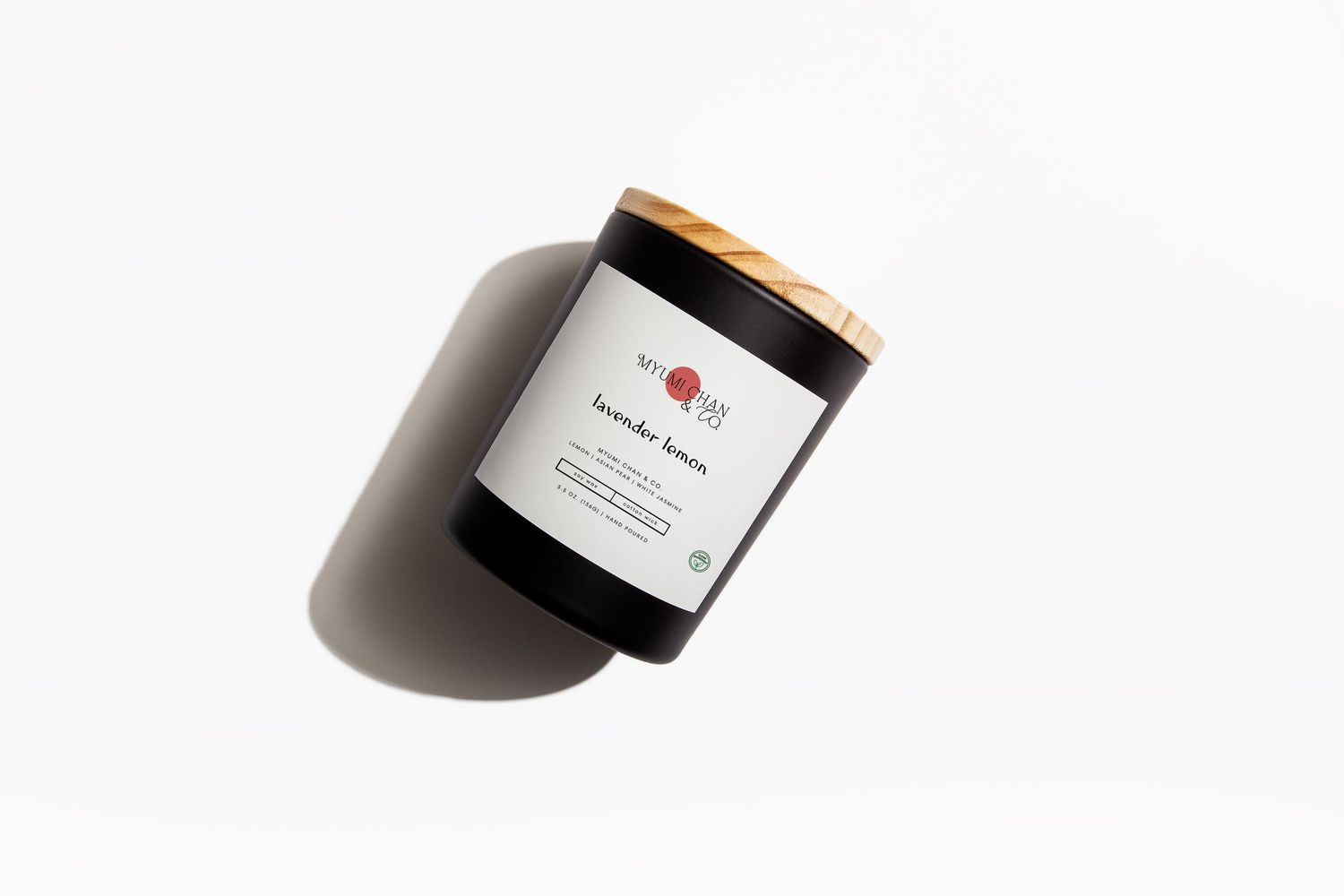 Black glass lavender scented candle with wooden lid and white label on a clean white background.