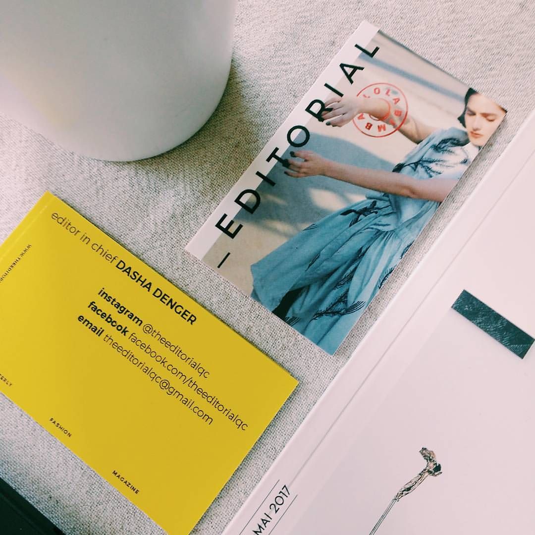 Editorial fashion magazine with yellow business card and model in blue dress on cover.