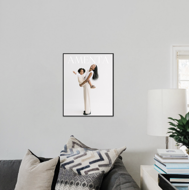 Framed magazine cover art print displayed on a living room wall above a gray sofa with patterned pillows.