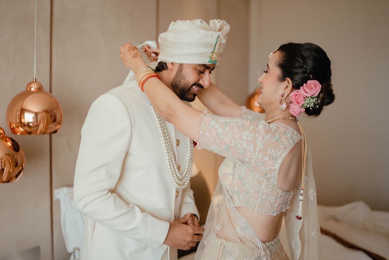 A couple in elegant wedding attire share an intimate dance moment at their reception.