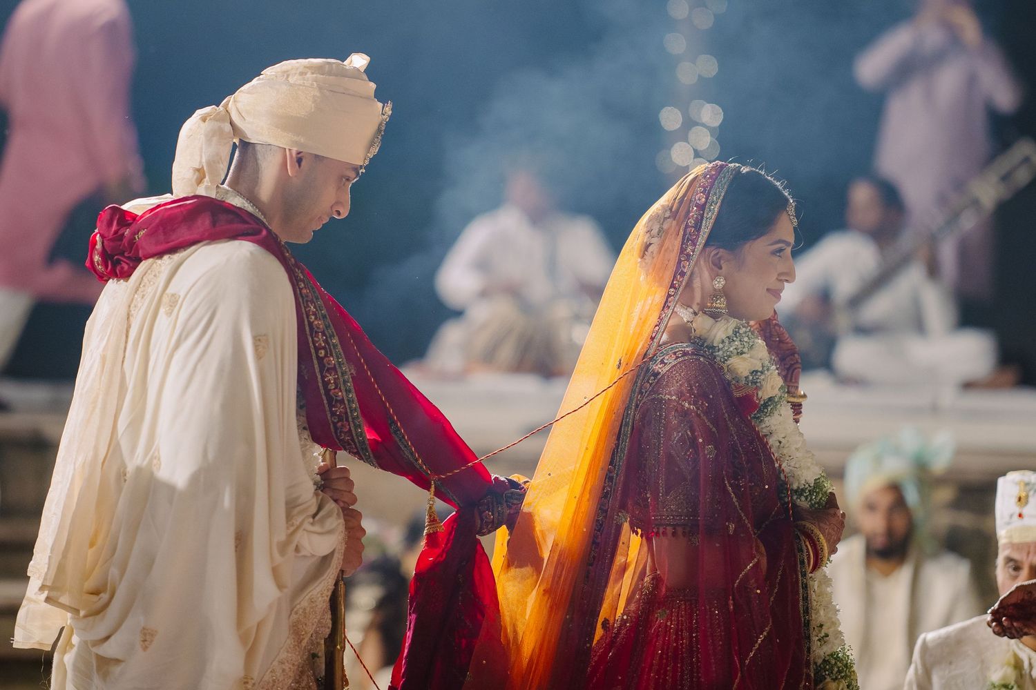 Traditional Indian wedding ceremony with guests gathered outdoors in colorful attire.
