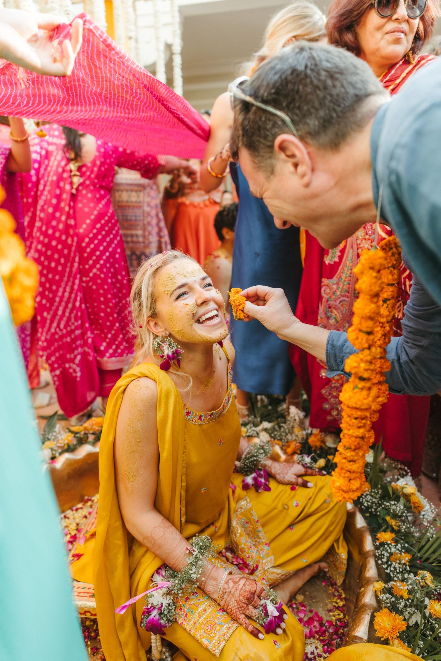 Candid moments of celebration with guests enjoying and throwing flower petals at an outdoor event.