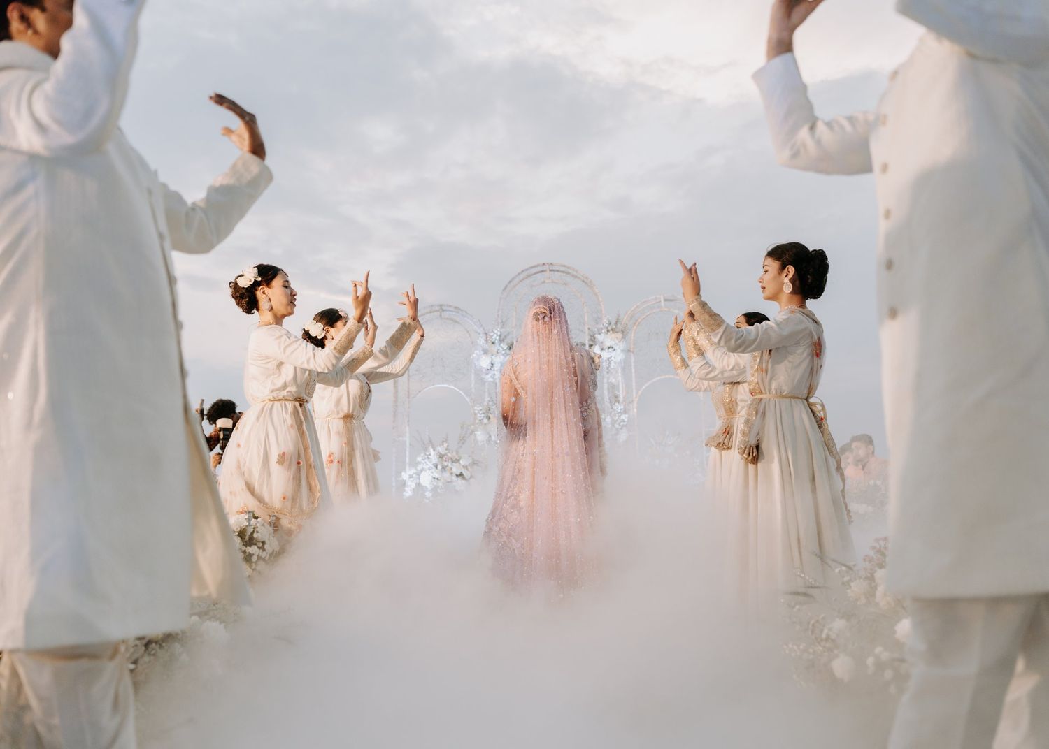 Group of dancers in white outfits performing graceful contemporary dance in a bright, minimalist studio space