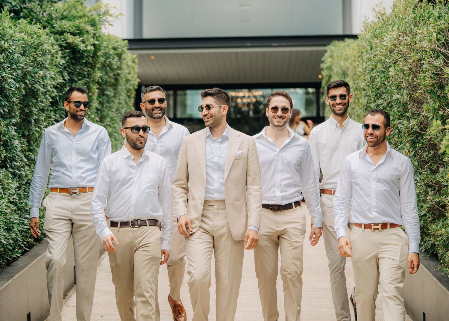 Wedding group portrait in coordinated summer attire with khaki pants and white shirts outdoors, photographed by Studio RDP Goa