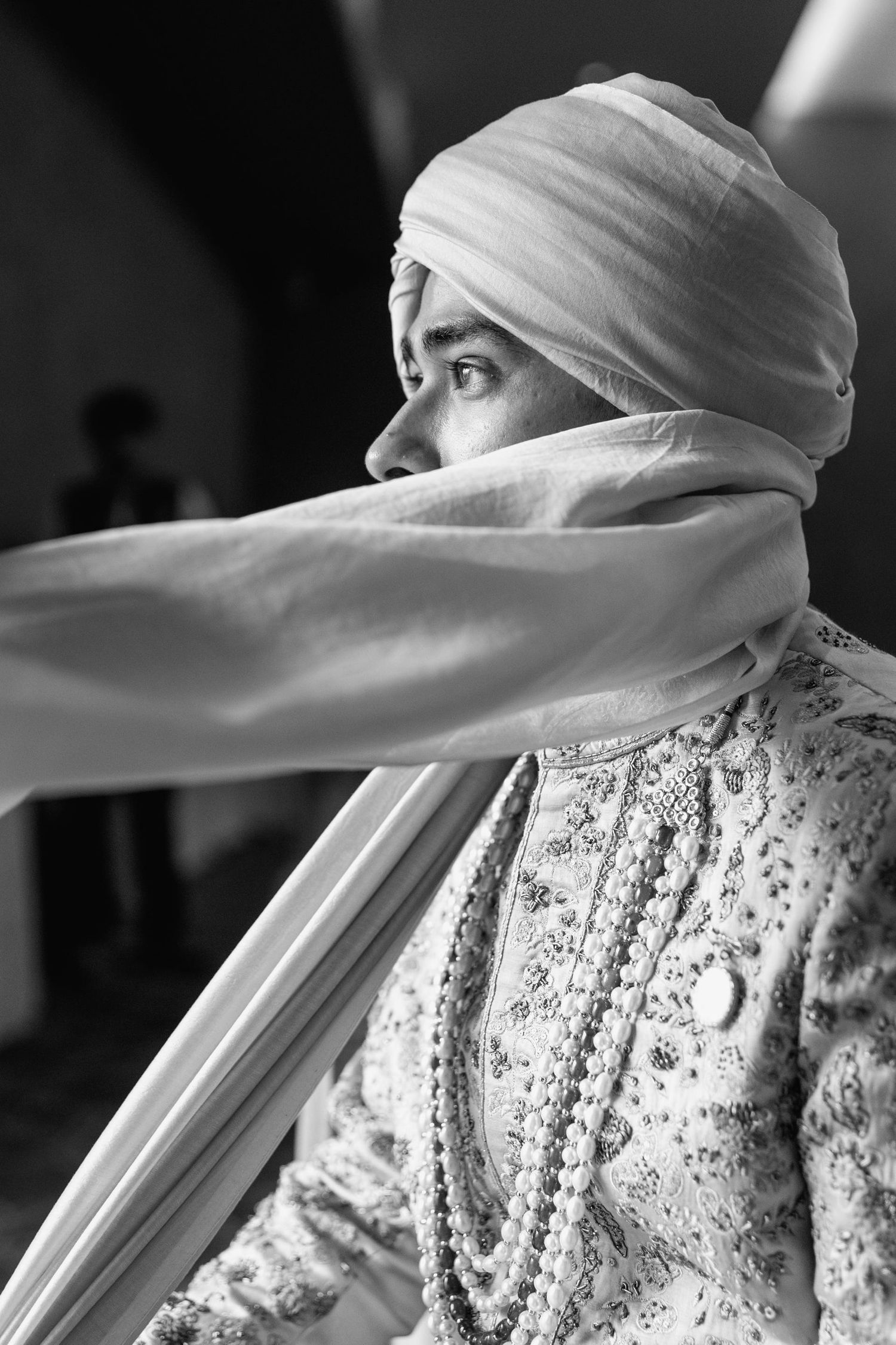 Black and white artistic portrait series showing a person wearing a flowing white headscarf and patterned dress.