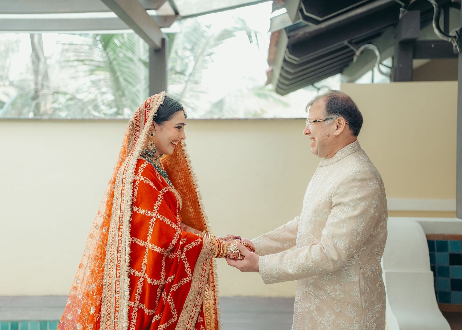 A couple in traditional Indian wedding attire performs a ritual during their marriage ceremony.
