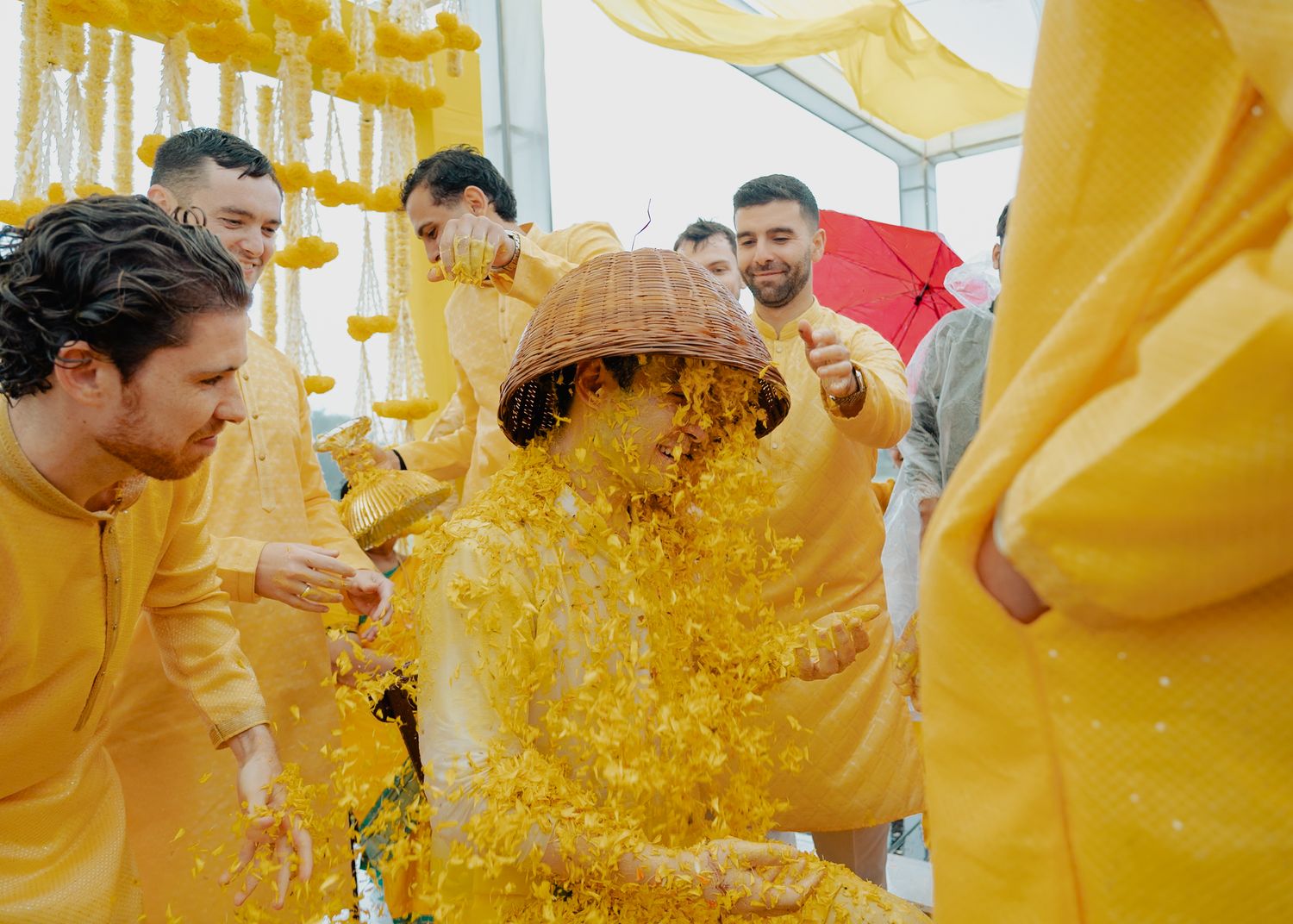 Guests participate in a traditional Haldi ceremony with yellow turmeric powder being playfully thrown during celebrations.