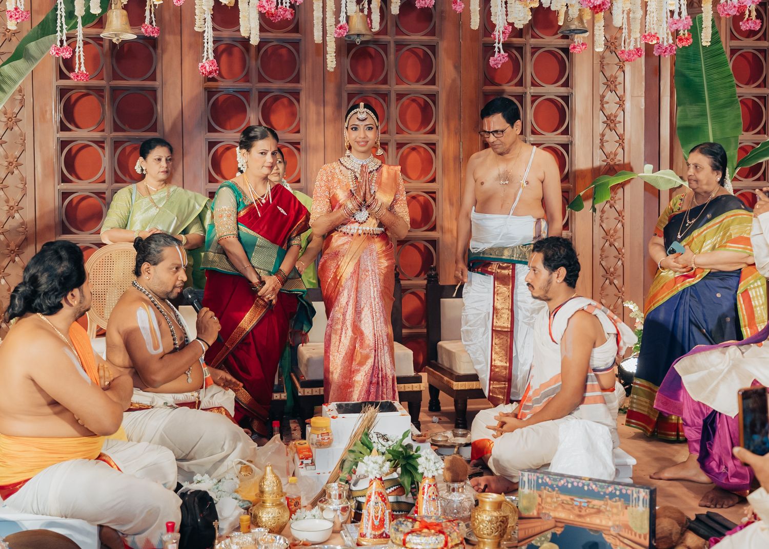 Wedding celebration scene with guests seated at decorated tables in ornate indoor venue.