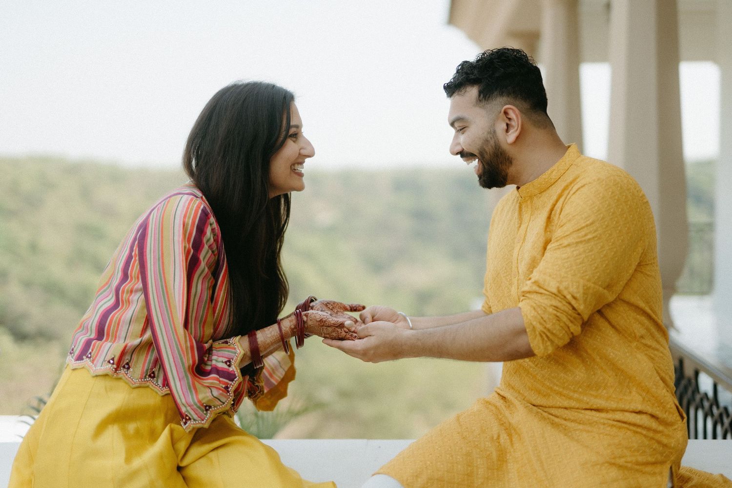 A couple in yellow and black outfits smile and laugh together in a sequence of candid portraits.