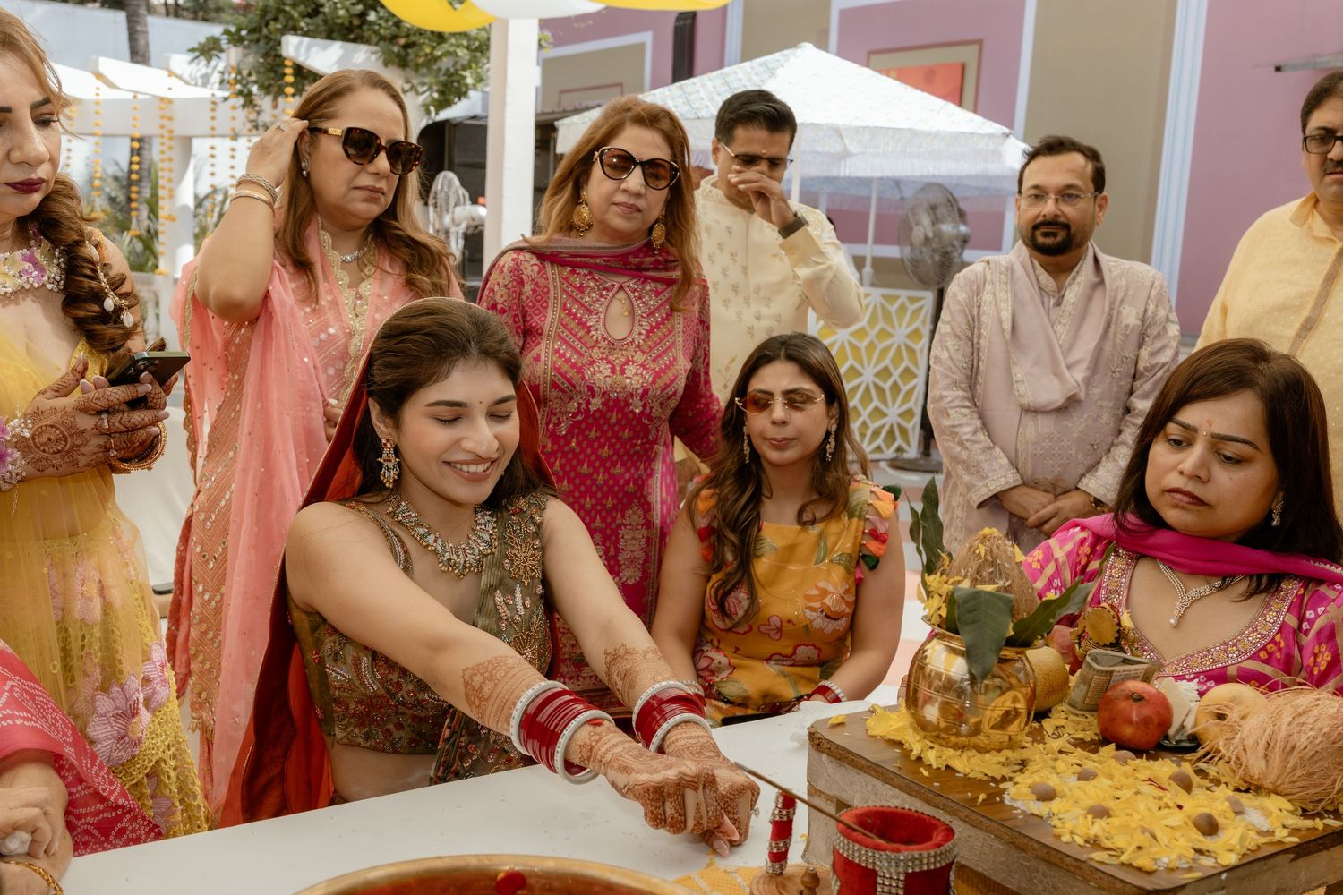 A colorful Indian wedding celebration with guests gathered around a buffet table serving traditional food and snacks.