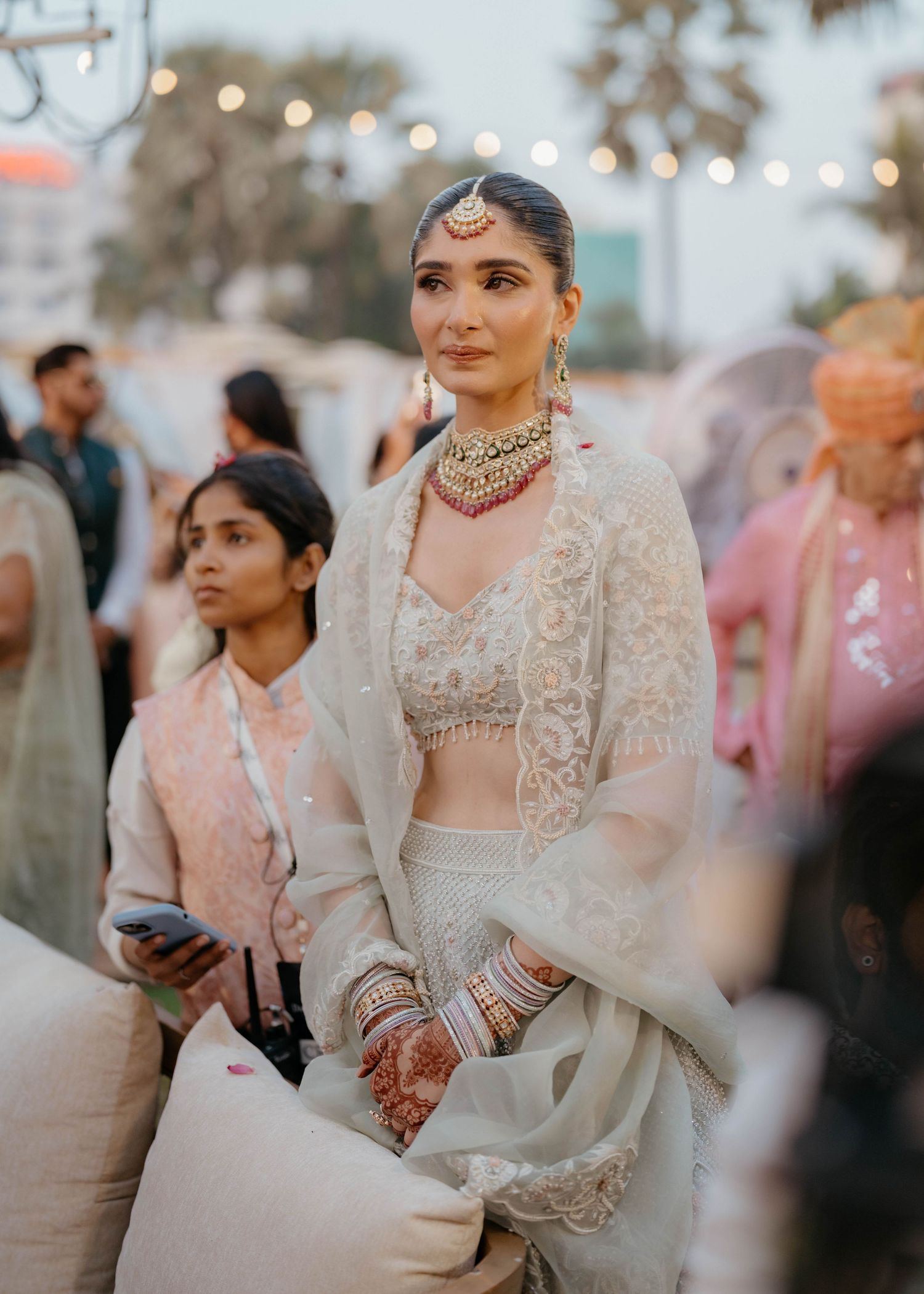 Bride’s sister dressed in an elegant embroidered light grey lehenga with statement jewelry at Nastasia and Jeet’s wedding at Taj Lands End M