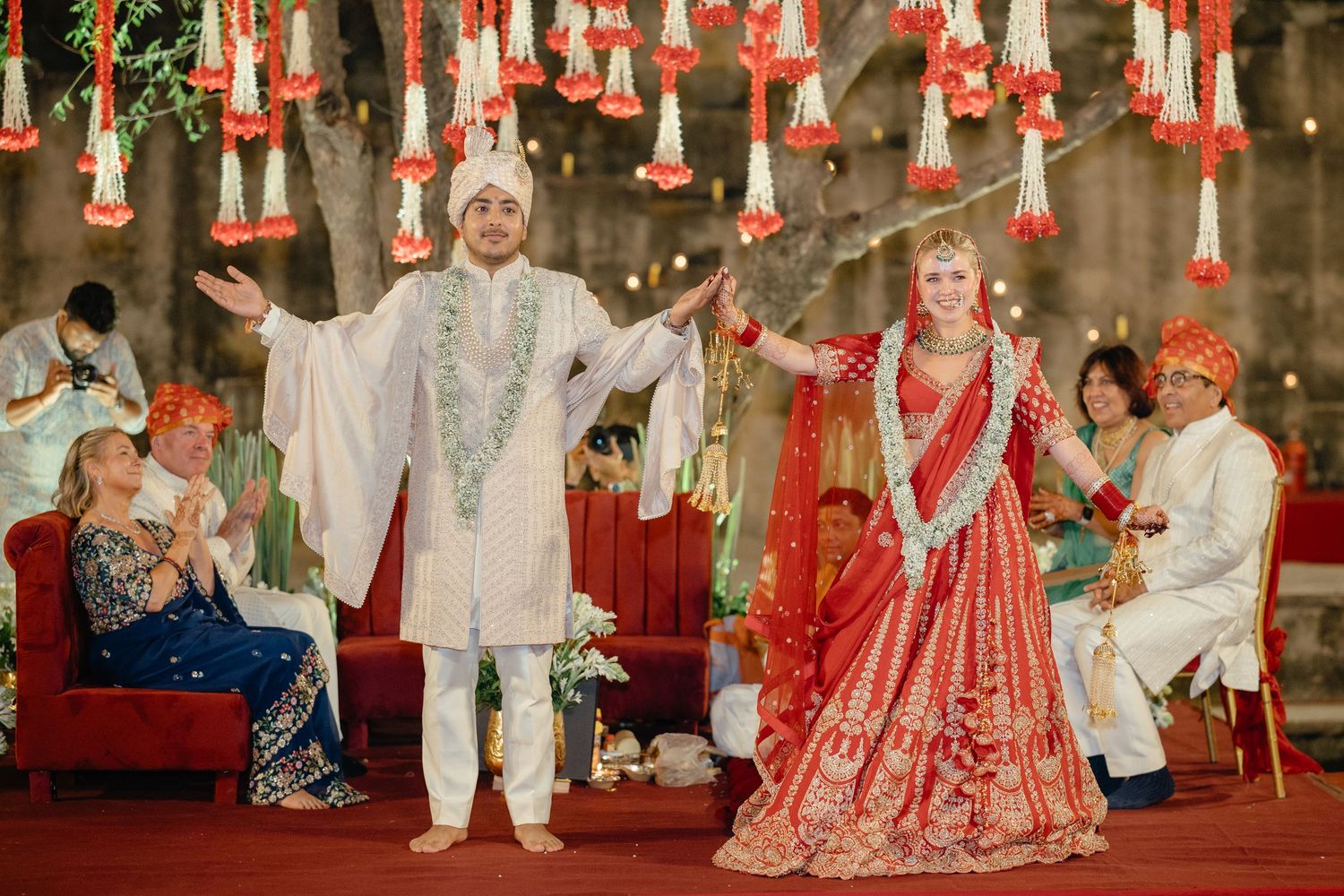 Wedding ceremony space adorned with red hanging decorations and ambient lighting.