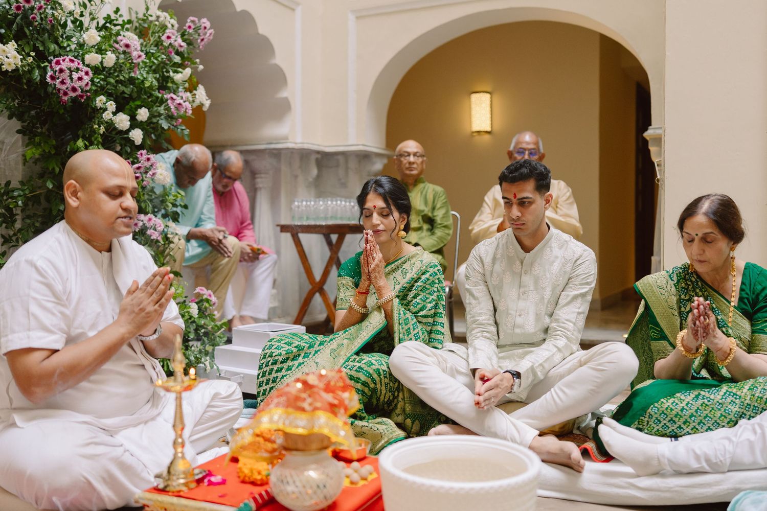 Guests gather around a table for a traditional Indian wedding celebration meal.