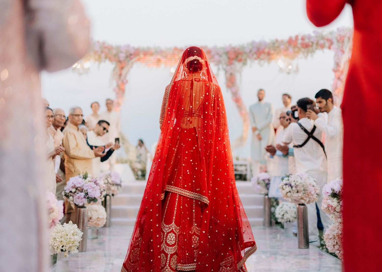 Wedding couple stands together in ornate traditional attire during their ceremony celebration.