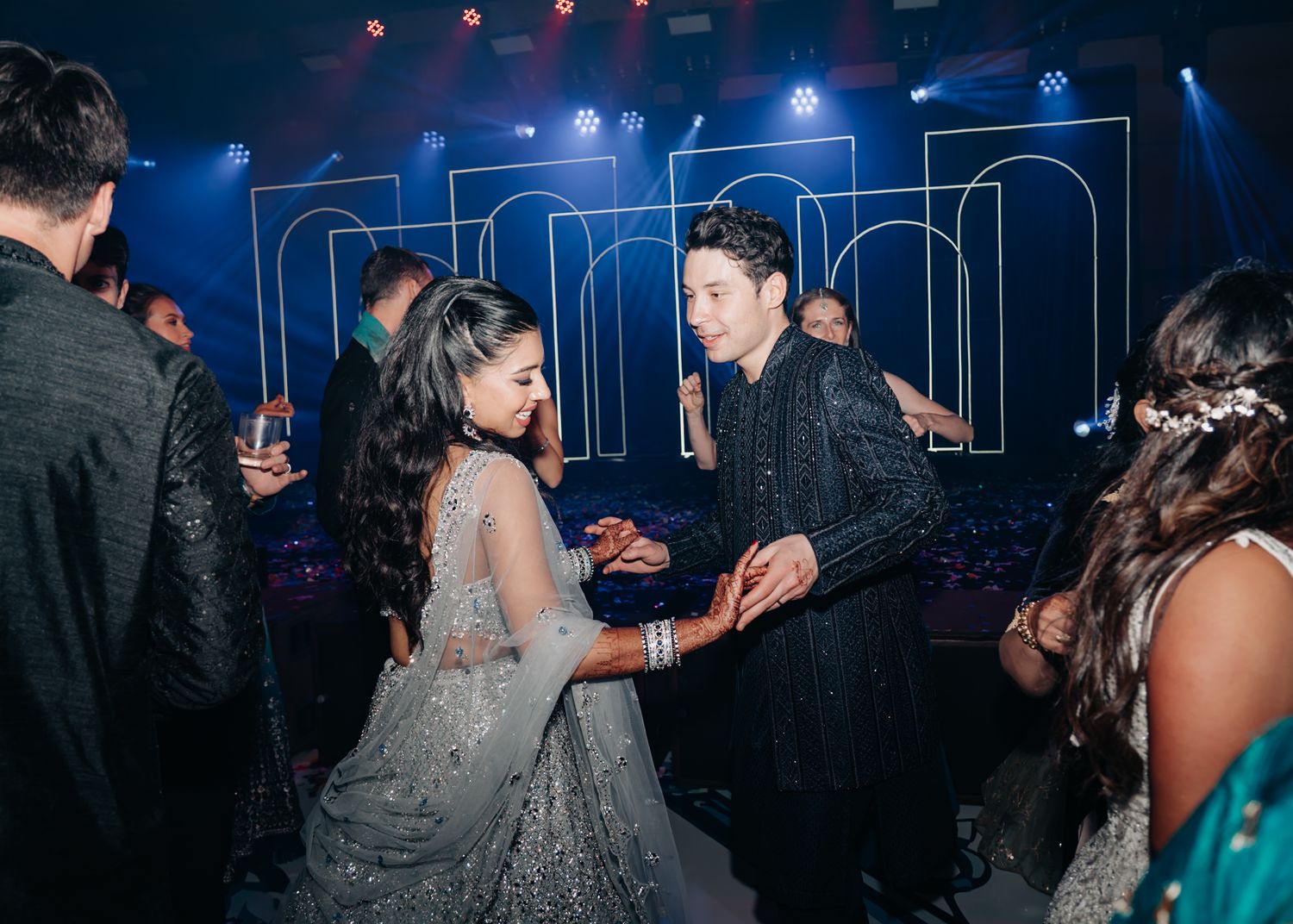 Wedding reception dance party with blue lighting and festive atmosphere.