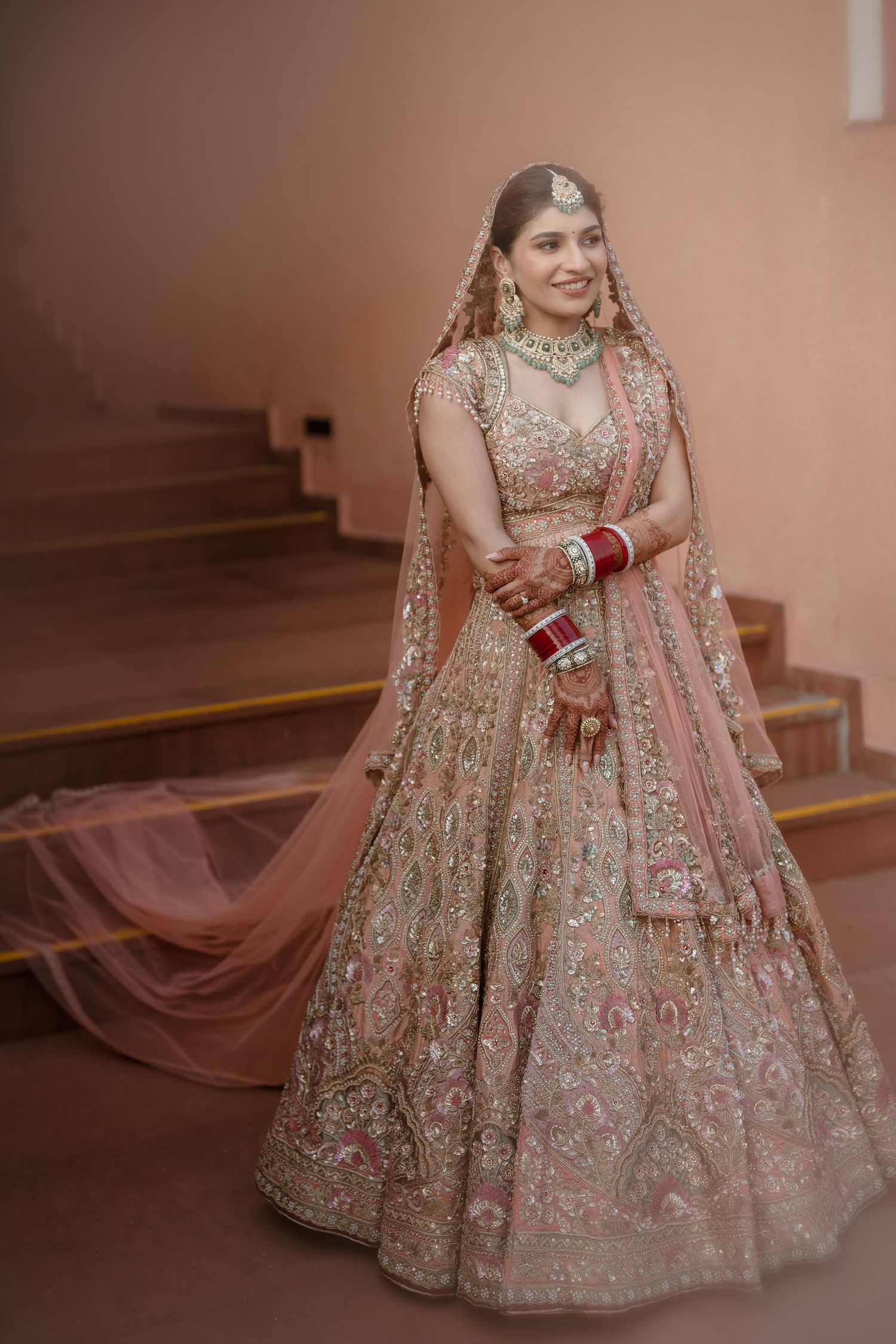A detailed view of an ornate pink and gold lehenga with intricate embroidery and embellishments showcased in multiple angles.