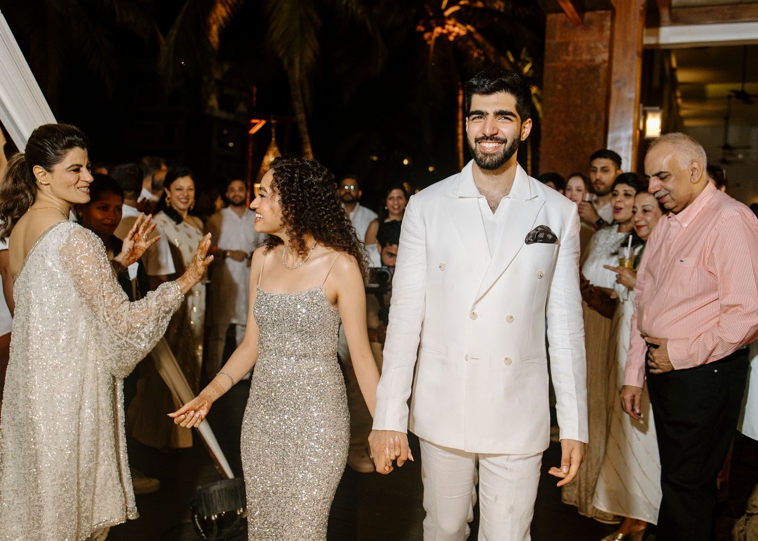 Wedding reception guests dance and celebrate on a lively dance floor under warm lighting.