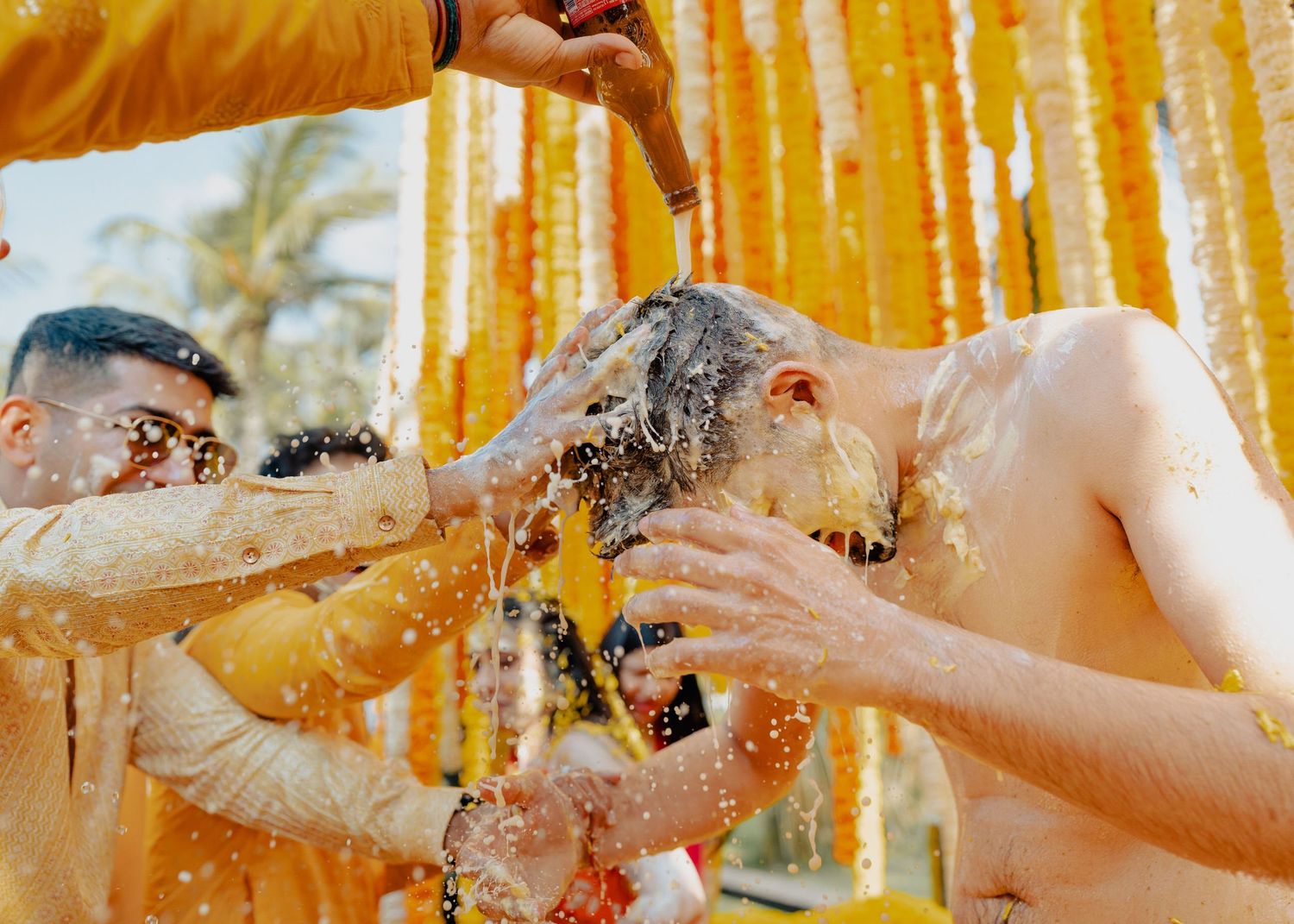 Traditional Indian pre-wedding Haldi ceremony with turmeric paste being applied amidst yellow marigold decorations.